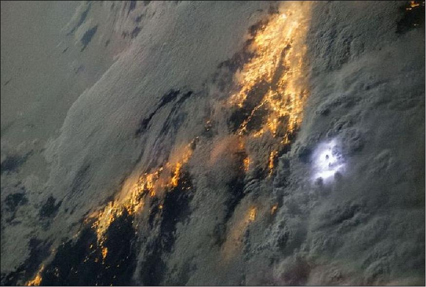 Cette image prise de l'ISS au-dessus de la Californie montre la foudre comme une lueur blanche sur le côté droit à partir du centre de l’image. Les zones éclairées en jaune sous les nuages sont les régions densément peuplées de Los Angeles et de San Diego visibles grâce à l'éclairages publics (Crédit : NASA, ISS036-E-022863, 21 juillet 2013).