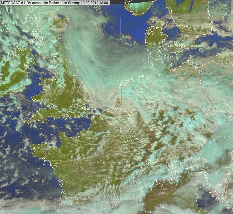 Meteosat-beeld in het zichtbare kanaal: zondag 10/3 om 13u. Kern van het lagedrukgebiedruk over Nederland. Zone van (zeer) sterke wind net ten zuiden ervan (over onze regio's) met buien.